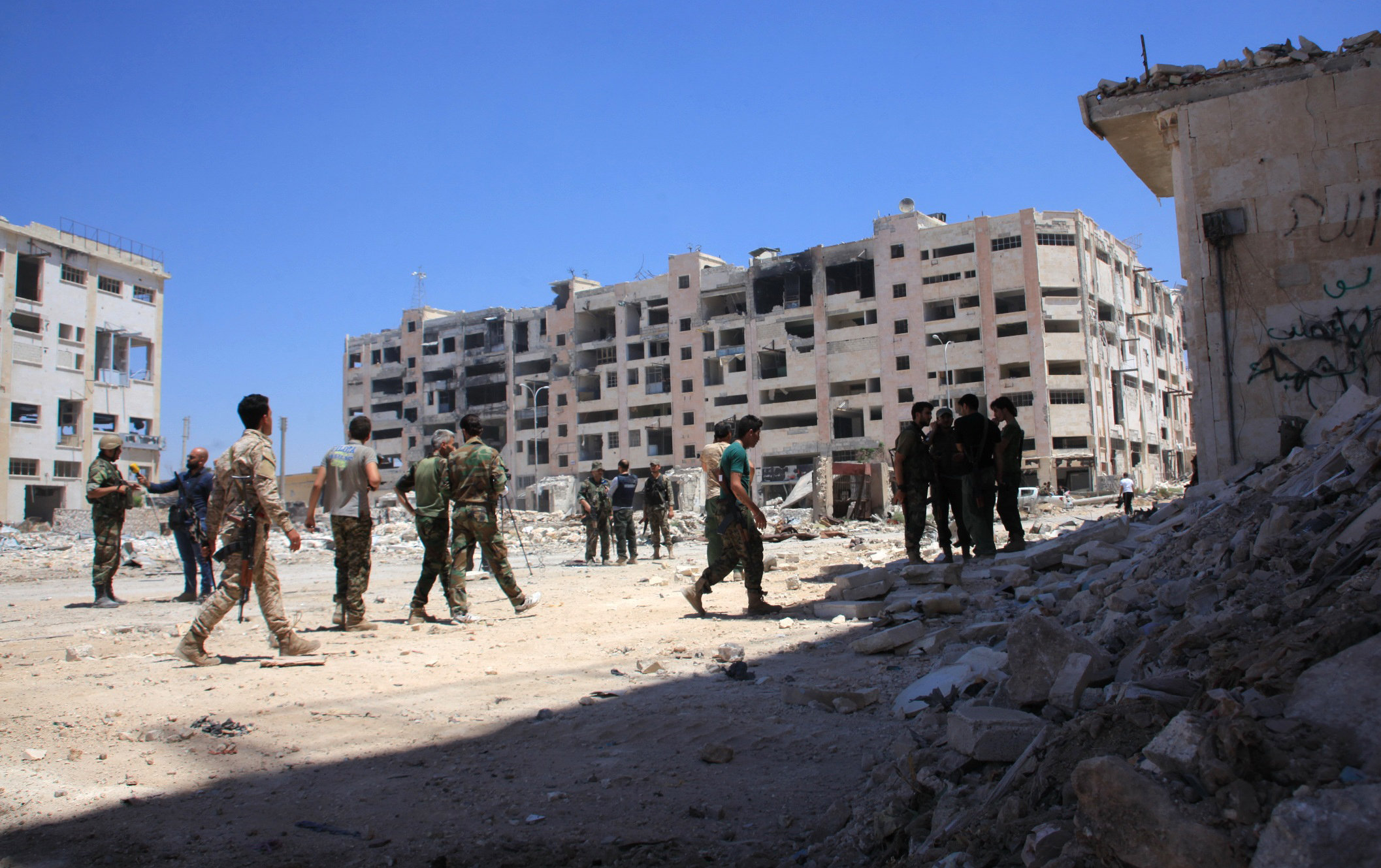 Syrian army soldiers patrol the area around the entrance of Bani Zeid after taking control of the previously rebel-held district of Leramun, on the northwest outskirts of Aleppo, on July 28, 2016